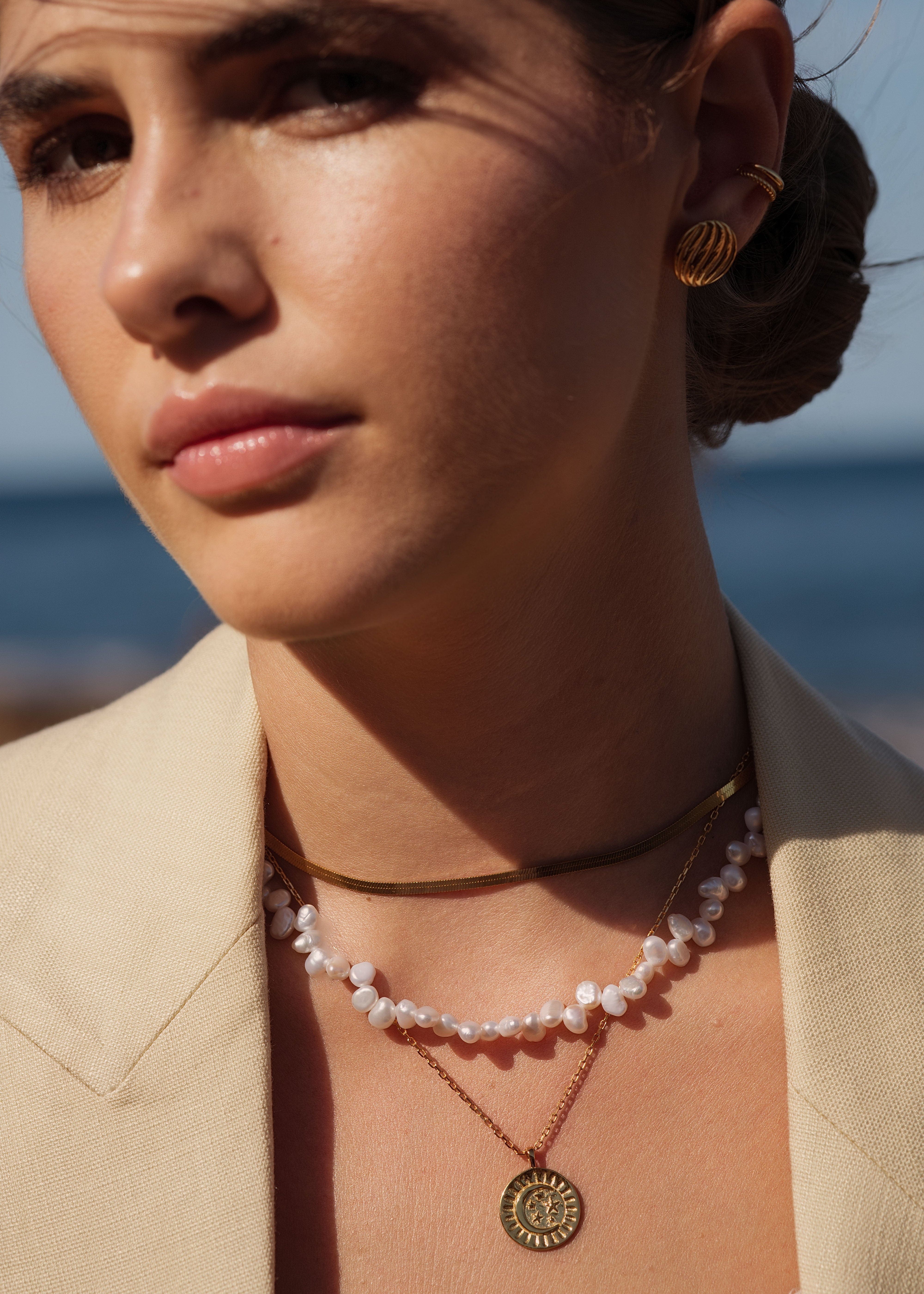 model trägt ellenoe schmuck aus gold und perlen